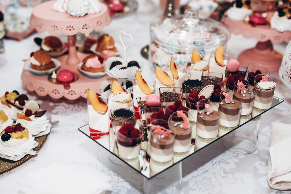 delicious candy bar at luxury  wedding reception. exclusive expensive catering. table with modern desserts, cupcakes, sweets with fruits. space for text. baby or bridal shower. holiday celebration